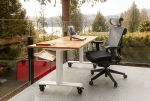 Escritorio elevable con silla ergonómica junto a una ventana